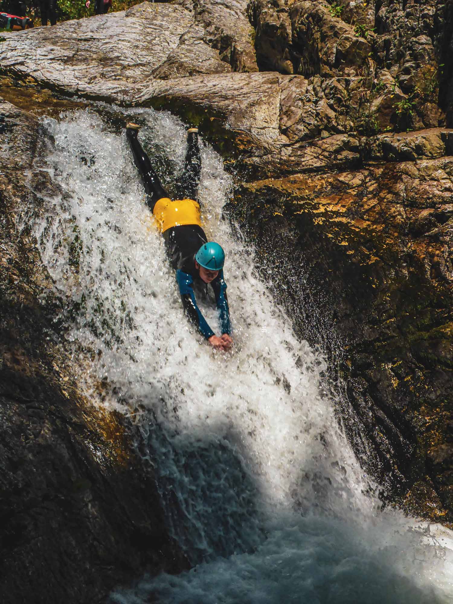 Un enfant dans un toboggan la tête en avant sur le parcours canyoning demi-journée Azéro en Ardèche avec Nature Canyon