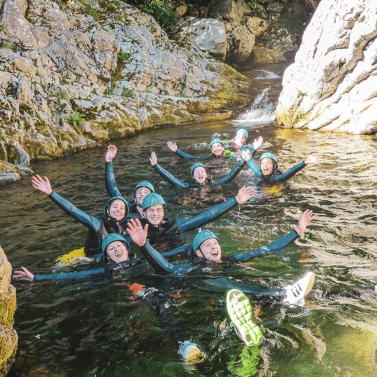 Groupe de jeunes adultes réunis dans une vasque d'eau sur le parcours canyoning Azéro avec Nature Canyon Ardèche