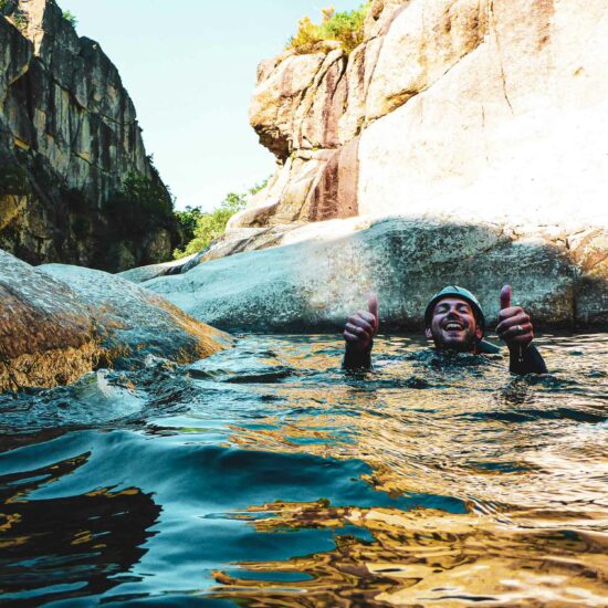 Un pratiquant de canyoning nageant sur le dos dans la rivière du Chassezac avec Nature Canyon Ardèche