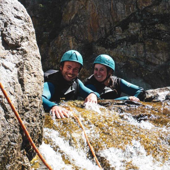 Un couple au sommet d'une cascade dans le canyon aventure journée du Chassezac intermédiaire avec Nature Canyon Ardèche